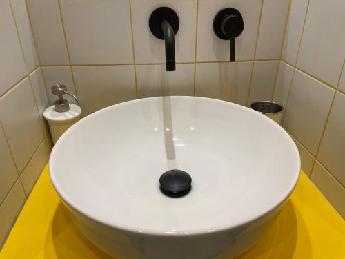 a white sink in a bathroom with a faucet at Dusmè in Taranto