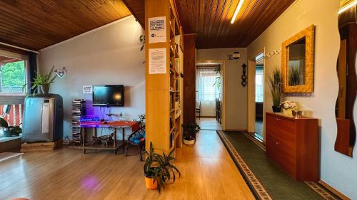 a room with a hallway with a table and a tv at Napfény vendégház in Győr