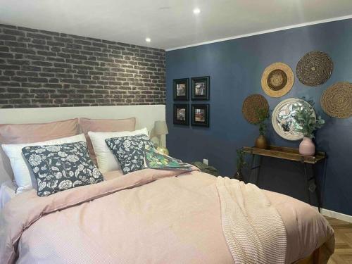 um quarto com paredes azuis e uma cama com almofadas em la planque d'hugo em Jumièges