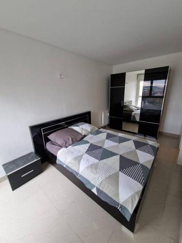 a bedroom with a bed and a mirror at Résidence Du Grand Stade in Saint-Denis