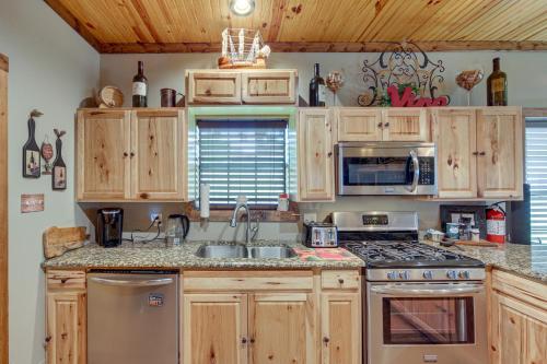 a kitchen with wooden cabinets and a stove top oven at Jefferson Vacation Rental with Golf Cart! in Jefferson