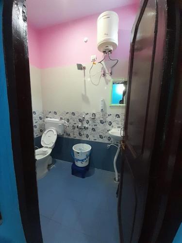 un baño con inodoro y lavabo en SOMESH Holiday Home, en Uttarkāshi
