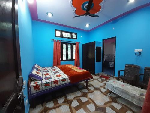 a blue bedroom with a bed and a ceiling fan at Somesh Homestay in Uttarkāshi