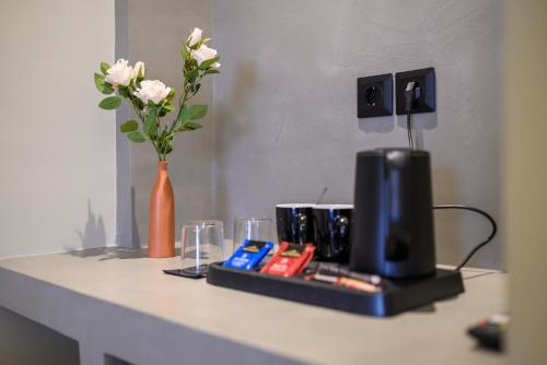 a table with a television and a vase with flowers at Nicolas Grand Suites, Adults Only in Kardamaina
