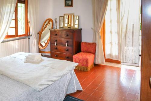 a bedroom with a bed and a dresser and a mirror at Apartment at Villa Lorenzo in Villa Collemandina