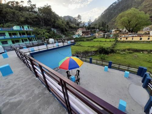 two people standing under an umbrella next to a pool at Somesh Homestay in Uttarkāshi