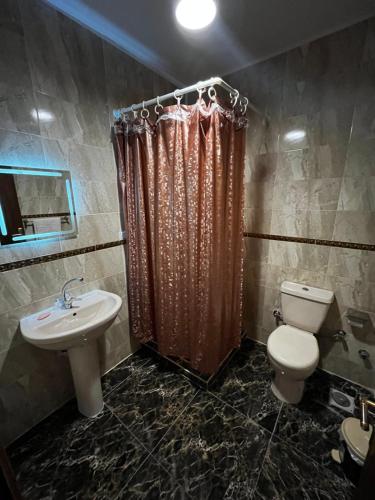 een badkamer met een toilet, een wastafel en een douche bij King hur pyramids inn in Caïro
