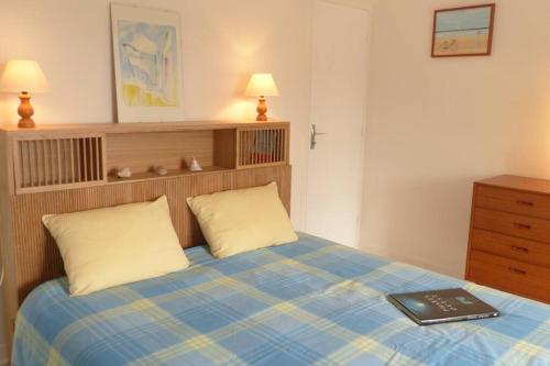 ein Schlafzimmer mit einem Bett mit einem Buch darauf in der Unterkunft Crac’h, grande maison de vacances au calme in Crach