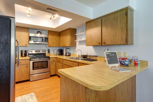 a kitchen with wooden cabinets and a counter top at Idyllic Fort Pierce Retreat - Walk to Beach! in Fort Pierce