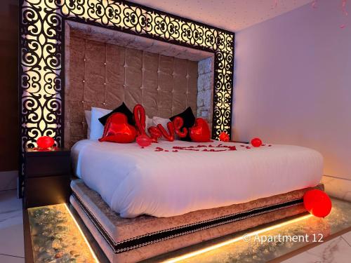 a bedroom with a large bed with red pillows at Mansa Apartments in Bradford