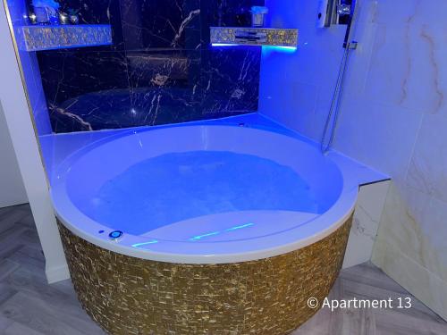 El baño incluye una gran bañera azul. en Mansa Apartments en Bradford