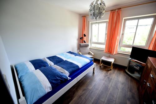 um quarto com uma cama, uma secretária e 2 janelas em Ferienwohnung Laubegast em Dresden