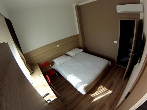 a small bedroom with a bed and a chair at Sweet Dreams Rooms and Apartments Postojna in Postojna