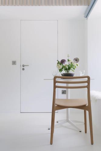 a table and a chair with a plant on it at Eastside - Architect designed retreat with wood-fired sauna in Penicuik