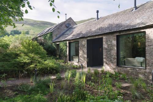 an old stone cottage with a window and a door at Eastside - Architect designed retreat with wood-fired sauna in Penicuik