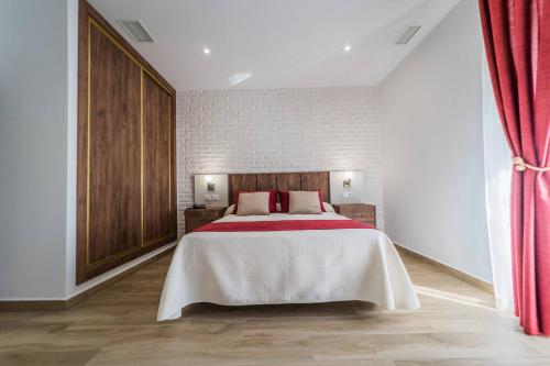 a bedroom with a large bed with red curtains at HOTEL RURAL LA TEJA in Segura de León