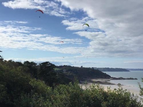 a group of kites flying in the sky over the water at Maison Caroual Erquy 500m de la PLAGE in Erquy