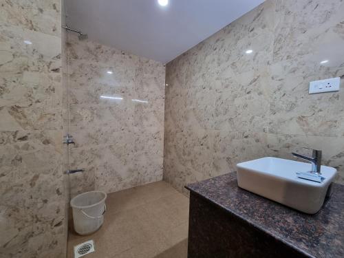 a bathroom with a sink and a shower at Rishikesh Resort Lonavala in Lonavala