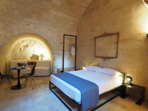 1 dormitorio con 1 cama, 1 mesa y 1 silla en Dimore dei Mercanti en Matera