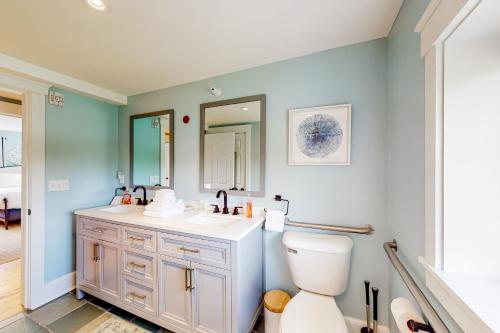 uma casa de banho com um WC, um lavatório e um espelho. em The Farmhouse - Suite #1 em Waterbury