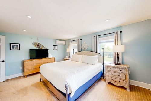 um quarto com uma cama grande e uma televisão em The Farmhouse - Suite #1 em Waterbury