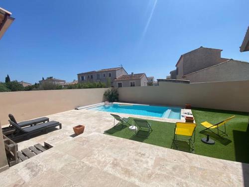 une cour avec une piscine et des chaises dans l'établissement Birds Villa, piscine chauffée, clim, garage, wifi, à Arles