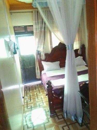 Kabale的住宿－City Max hotel Kabaale，一间卧室配有两张床和窗帘