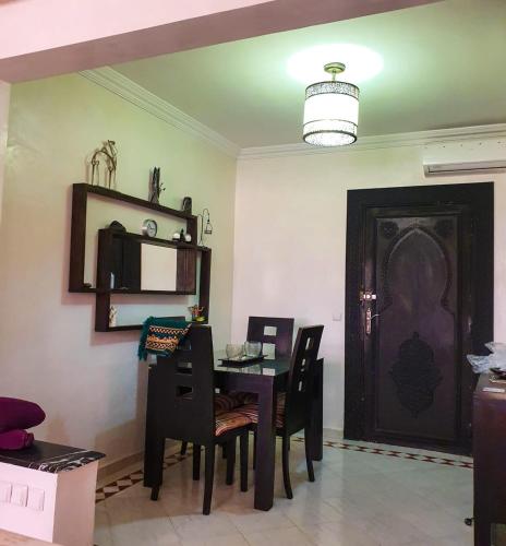 ein Esszimmer mit einem Tisch, Stühlen und einer Tür in der Unterkunft Merzouga apartments in Merzouga