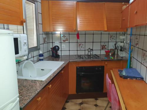 una pequeña cocina con fregadero y microondas en Cal Tendre, en Albagés