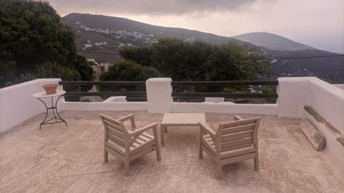 un patio con 2 sedie e un tavolo con vista di Terra Aeolica ad Arnádhos