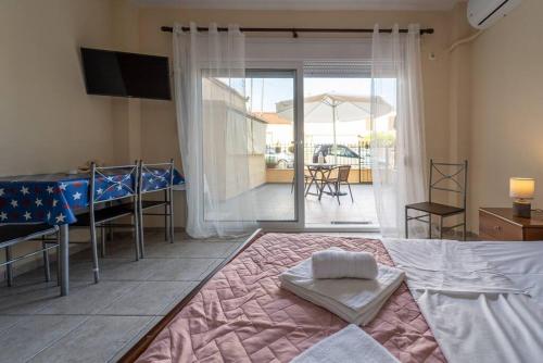 een slaapkamer met een bed en een tafel en een balkon bij Cleri's Studio in Néa Péramos