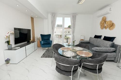 a living room with a couch and a table and chairs at Katja Malo Misto in Zadar