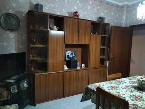 a large wooden cabinet in a room with a table at Maremonti in Zafferana Etnea