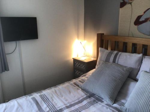 a bedroom with a bed with a television on the wall at City apartment no.8 in Norwich