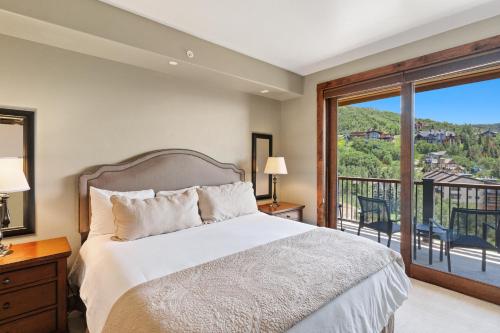 a bedroom with a bed and a balcony at Edgemont 2504 - Luxury Ski-in Ski-out Condo in Steamboat Springs