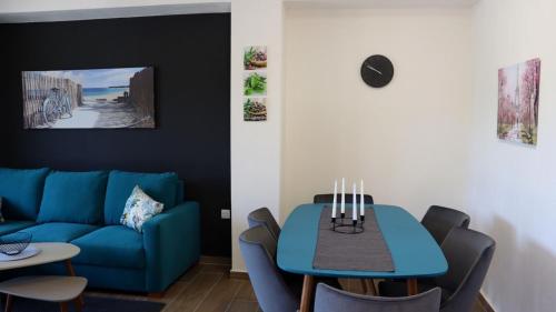 een woonkamer met een blauwe bank en een tafel bij Martini Villas in Nikiti