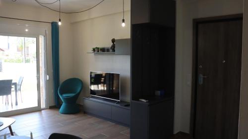een woonkamer met een open haard en een blauwe stoel bij Martini Villas in Nikiti