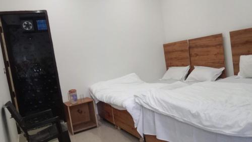 - une chambre avec 2 lits jumeaux et une chaise dans l'établissement Hotel Arindam, à Phata