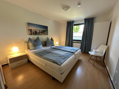 ein Schlafzimmer mit einem großen Bett und einem Fenster in der Unterkunft Gästehaus Bremer in Cuxhaven
