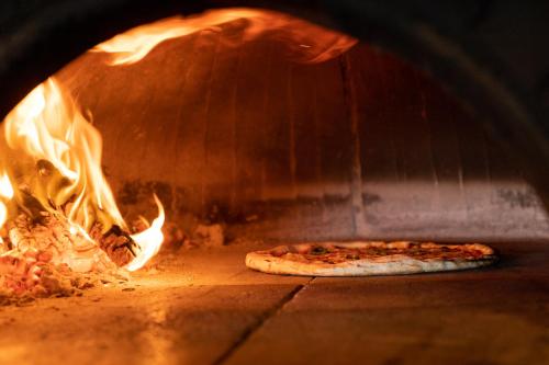a pizza is cooking in a brick oven at Eco Village Baia Delle Ginestre in Teulada