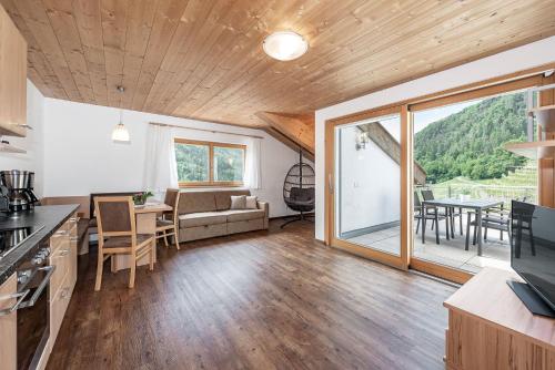 een keuken en een woonkamer met een bank en een tafel bij Appartements Toni in Feldthurns