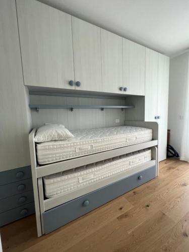 1 dormitorio con litera y armarios blancos en Sirio 7, en Lido di Jesolo