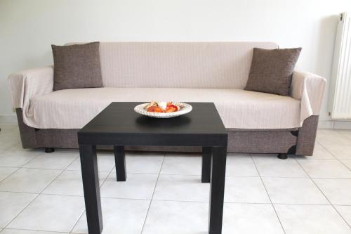 a coffee table with a bowl of fruit on a couch at Dabia Apartments in Mirina