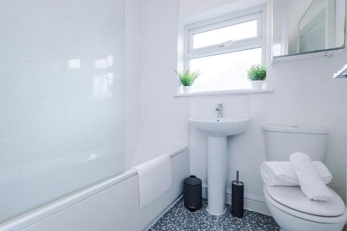 a white bathroom with a toilet and a sink at Stylish 2-bed home in Chester City-Centre by 53 Degrees Property, ideal for Couples & Small groups, Great Location - Sleeps 5 in Chester