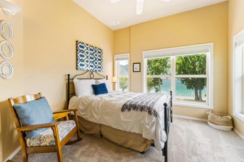 a bedroom with a bed and a window and a chair at Beaches and Breezes on Wapato - 4 Bed 4 Bath Vacation home in Wapato Point in Manson