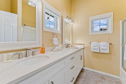 a bathroom with two sinks and a large mirror at Beaches and Breezes on Wapato - 4 Bed 4 Bath Vacation home in Wapato Point in Manson