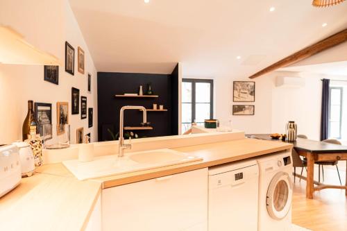 a kitchen with a sink and a washing machine at Centre historique coeur du quartier Vernet 100 m² in Avignon