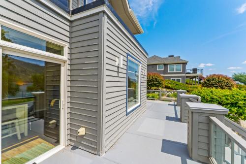 a house with a patio and a balcony at Beaches and Breezes on Wapato - 4 Bed 4 Bath Vacation home in Wapato Point in Manson