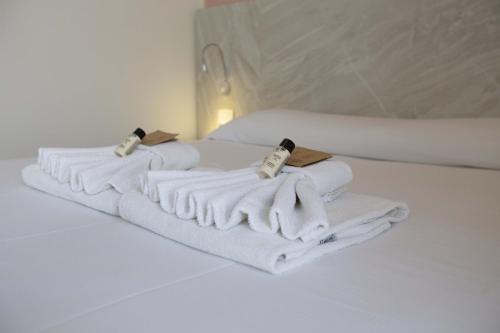 einen Stapel Handtücher auf dem Bett in der Unterkunft Hotel Confort in Rimini