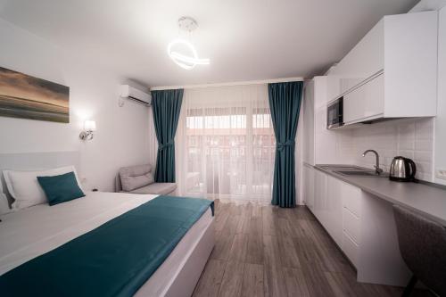 ein kleines Zimmer mit einem Bett und einer Küche in der Unterkunft Studio SARA in Saturn